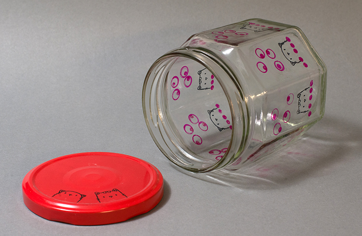 The lid of an upcycled jam jar decorated with matching cat image stamps using StazOn Jet Black ink.