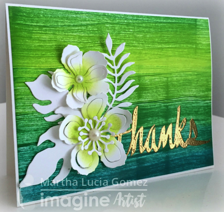 Handmade card featuring a textured looking background created using a direct to paper technique with Kaleidacolor Fresh Greens and a Floral die-cut centerpiece by Martha Lucia Gomez.