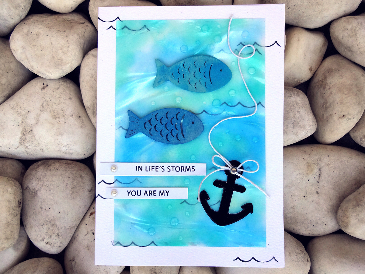 Handamade card featuring Imagine's Vertigo sheets colored and stamped to look like the sea with fish images and sentiment "you are my anchor" by Kyriakos of The Crafts World.